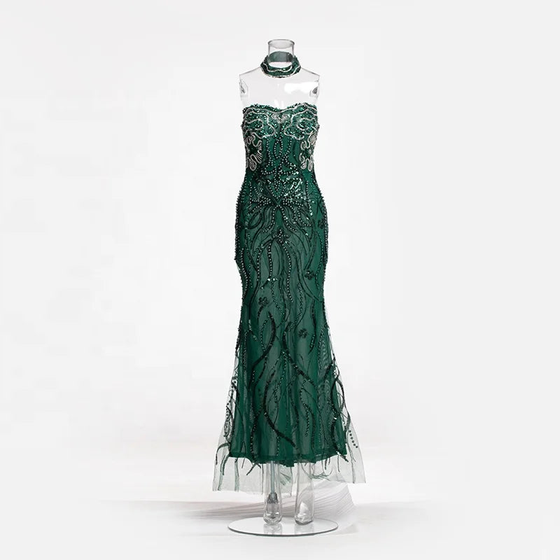 Vestido longo transparente verde-esmeralda com aplicações de ramos bordados com miçangas e choker combinando.