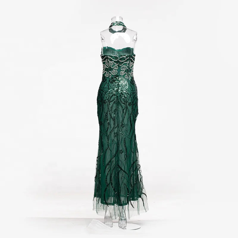 Vestido longo transparente verde-esmeralda com aplicações de ramos bordados com miçangas e choker combinando.