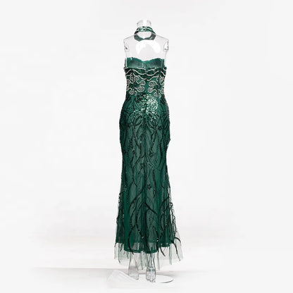 Vestido longo transparente verde-esmeralda com aplicações de ramos bordados com miçangas e choker combinando.