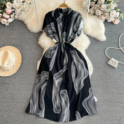 Vestido feminino midi de manga curta com decote em V, cintura marcada e modelagem evasê, da coleção de verão 2026 da Boutique Wholesale.