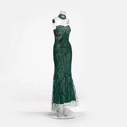 Vestido longo transparente verde-esmeralda com aplicações de ramos bordados com miçangas e choker combinando.