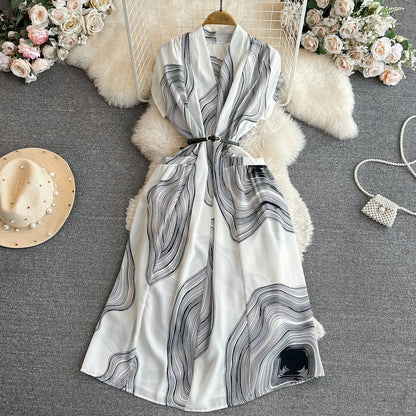 Vestido feminino midi de manga curta com decote em V, cintura marcada e modelagem evasê, da coleção de verão 2026 da Boutique Wholesale.