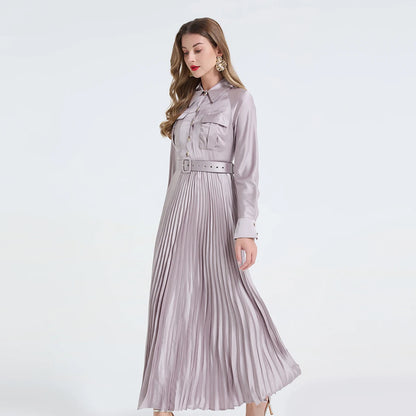 Vestido camisa feminino elegante, liso e plissado, com gola dobrável, mangas compridas, abotoamento simples e detalhe em viés. Acompanha cinto.