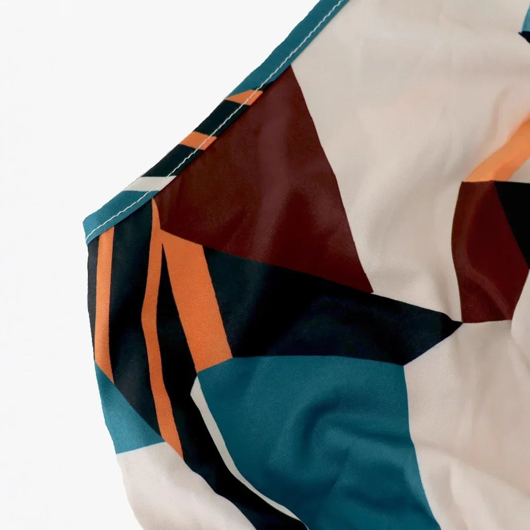 Vestido longo boêmio de gola alta, sem mangas, tamanho grande, com estampa geométrica e blocos de cores. Cintura alta com amarração e comprimento até o tornozelo.