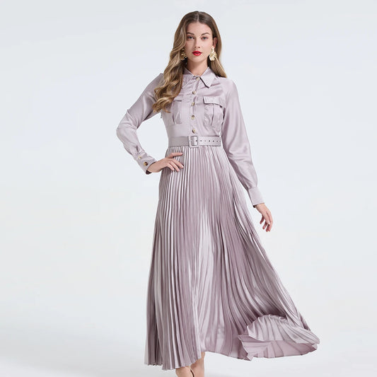 Vestido camisa feminino elegante, liso e plissado, com gola dobrável, mangas compridas, abotoamento simples e detalhe em viés. Acompanha cinto.