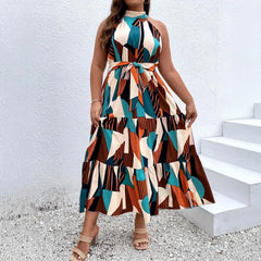 Vestido longo boêmio de gola alta, sem mangas, tamanho grande, com estampa geométrica e blocos de cores. Cintura alta com amarração e comprimento até o tornozelo.