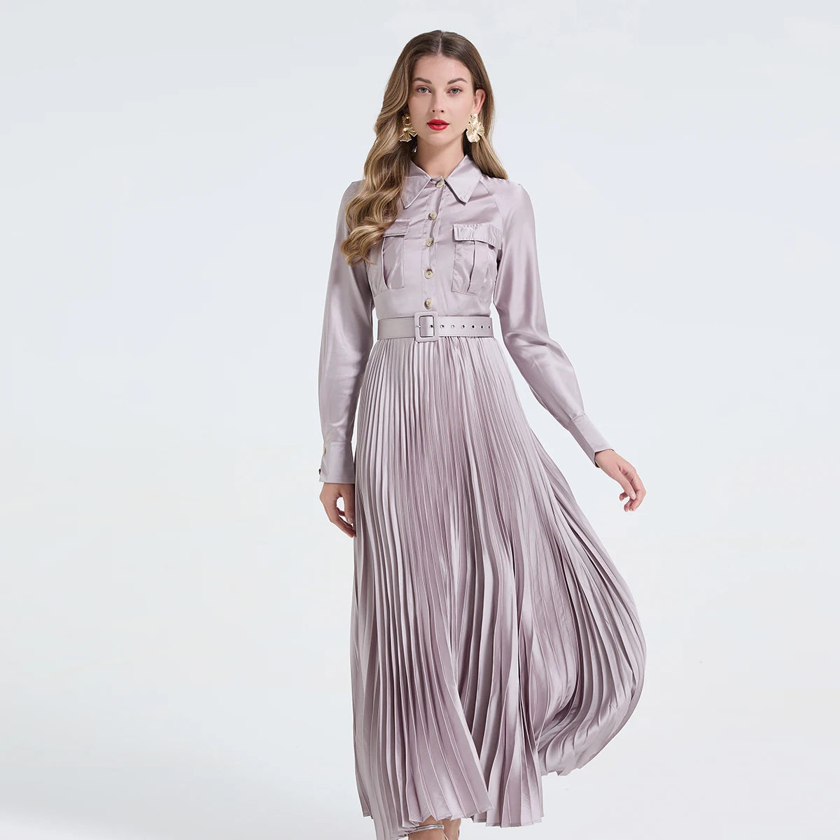 Vestido camisa feminino elegante, liso e plissado, com gola dobrável, mangas compridas, abotoamento simples e detalhe em viés. Acompanha cinto.