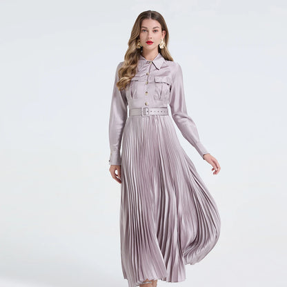 Vestido camisa feminino elegante, liso e plissado, com gola dobrável, mangas compridas, abotoamento simples e detalhe em viés. Acompanha cinto.