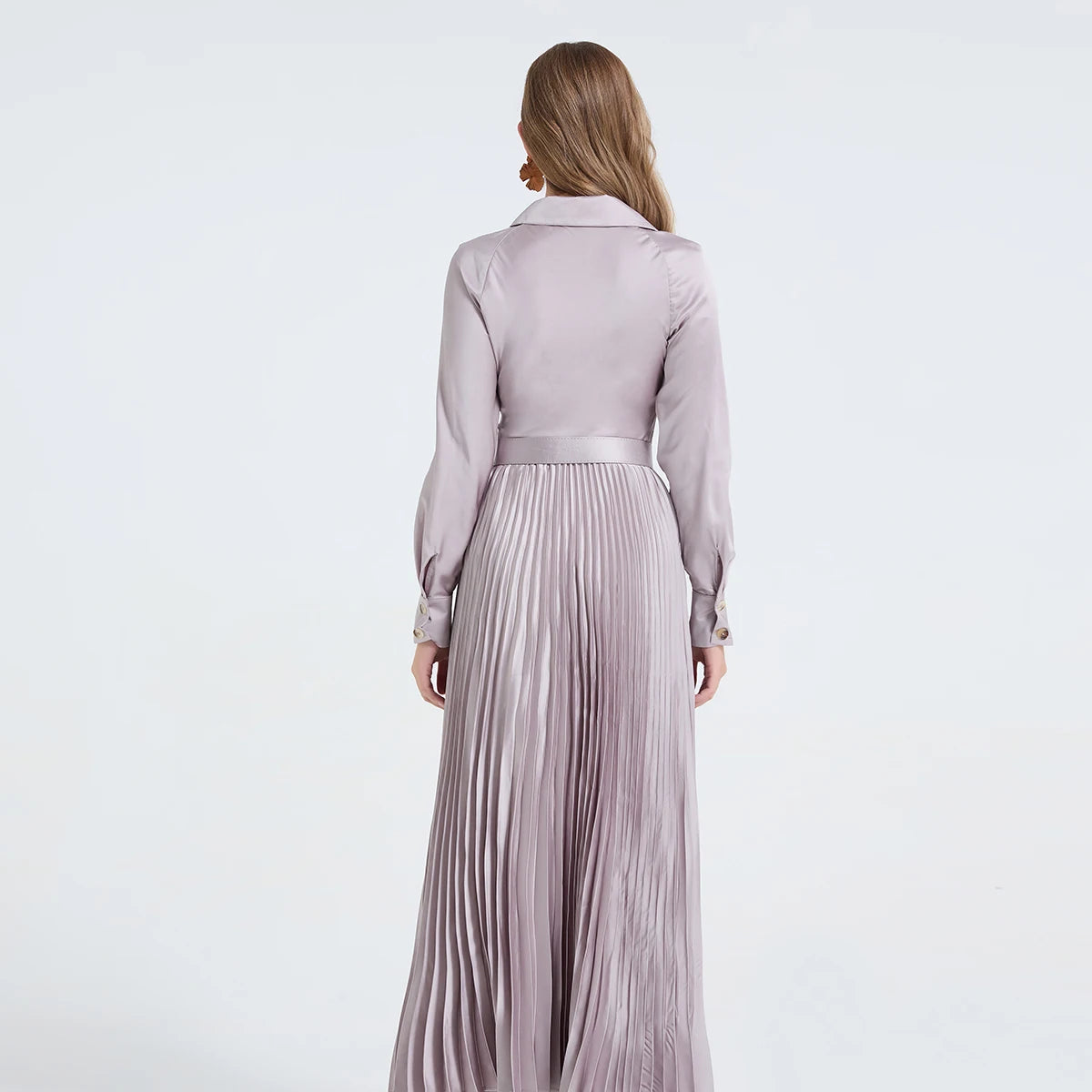 Vestido camisa feminino elegante, liso e plissado, com gola dobrável, mangas compridas, abotoamento simples e detalhe em viés. Acompanha cinto.