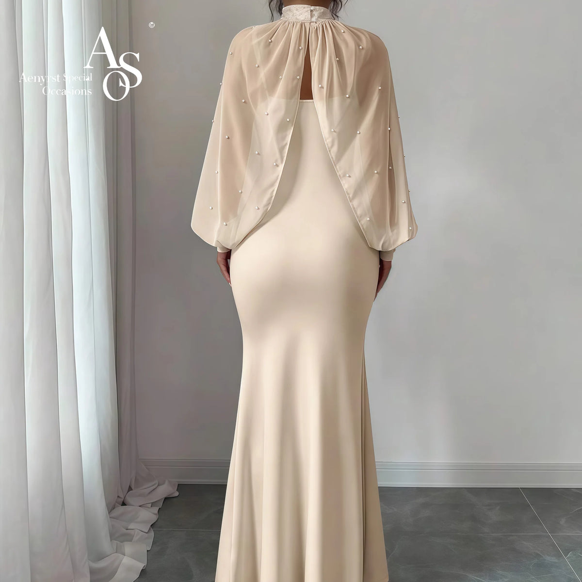 Vestido formal longo estilo sereia, sem alças, na cor marfim, com capa de gola alta e saia drapeada.